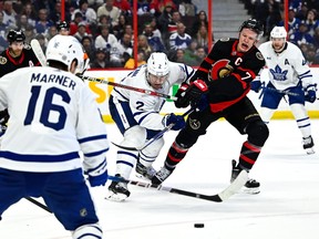 Ottawa Senators left wing Brady Tkachuk (7) is prevented from regaining control of the puck by Toronto Maple Leafs defenceman Luke Schenn (2) as right wing Mitchell Marner (16) looks on, during second period NHL hockey action in Ottawa, on Saturday, April 1, 2023.