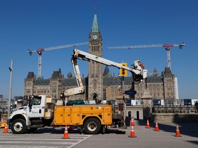 A City of Ottawa crew works Thursday on reinstalling traffic lights at a spot on Wellington Street directly in front of Centre Block on Parliament Hill.