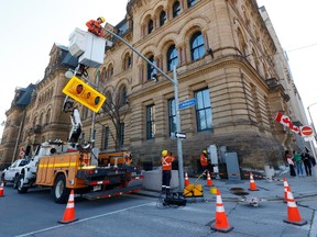 Ottawa crews reinstall traffic lights on Wellington Street in front of Parliament Hill earlier this month, in anticipation of reopening the street to vehicles.