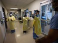 Nurses put on personal protective equipment at the Humber River Hospital in Toronto on Tuesday, January 25, 2022. Arbitrators have awarded Ontario hospital nurses additional salary increases for the three years that were subject to a wage restraint law, since it has been struck down as unconstitutional.