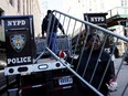 A person holds a barricade outside the Manhattan Criminal Court, after former U.S. President Donald Trump's indictment by a Manhattan grand jury following a probe into hush money paid to porn star Stormy Daniels, in New York City, U.S., April 2, 2023.