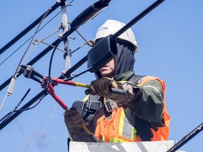 A Hydro worker works on a power line following an ice storm in Montreal, Friday, April 7, 2023. Hydro-Quebec says power has been restored to more than 90 per cent of the more than one million customers who lost electricity, but some of its remaining repairs may not be completed until Tuesday.