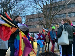 Clayton Goodwin holds rainbow flags at a demonstration outside the Ottawa-Carleton District School Board headquarters on April 4.