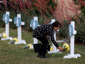 ALLEN, Texas, May 8: Gina Bennet places flowers in a memorial set up near the mall where a shooter opened fire, killing eight people.