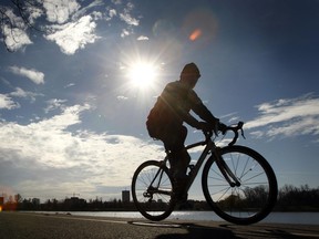 A cyclist pedals along the bicycle path around Dow's Lake on a sunny Ottawa day.