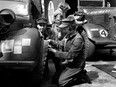 This undated archive photo of Princess Elizabeth shows her checking the tires during mechanic training in the Second World War.