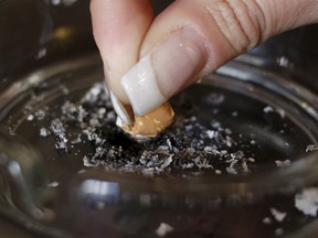 A woman stubs out a cigarette in an ashtray
