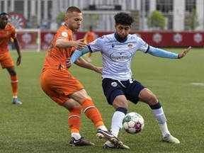 Forge FC defender Rezart Rama, left, fights for a ball with Atlético Ottawa midfielder Zakaria Bahous during Canadian Championship quarterfinal action at Tim Hortons Field in Hamilton on Tuesday.