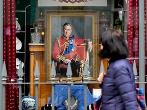 A woman walks by a storefront featuring King Charles III in London on May 2, 2023.  While he was still prince, Charles proved almost impossible to shut up.