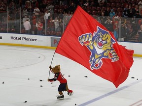 With the ice littered by plastic rats the Florida Panthers mascot skates with the club banner after the game against the Calgary Flames on December 16, 2011 at the BankAtlantic Center in Sunrise, Florida.