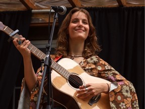 Une photo de l'auteur-compositeur-interprète Sofia Duhaime tenant une guitare sur scène.