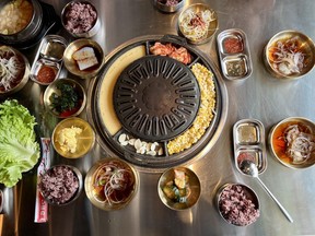 A table-top burner at Daldongnae Korean BBQ on Somerset Street West, surrounded by side dishes and accoutrements