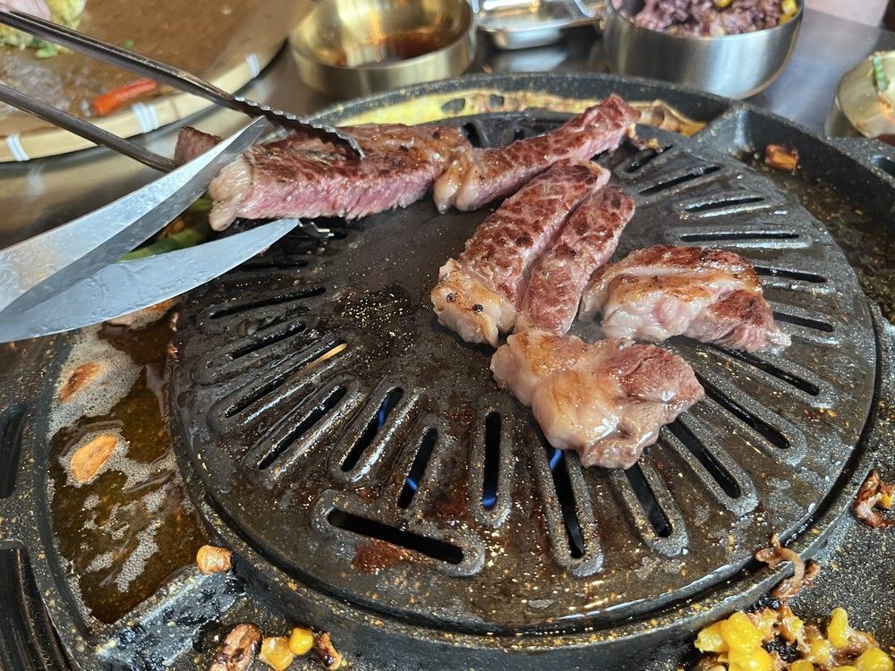 Guests use tongs and special meaet shears to turn and cut their barbecued meats at Daldongnae Korean BBQ on Somerset Street West