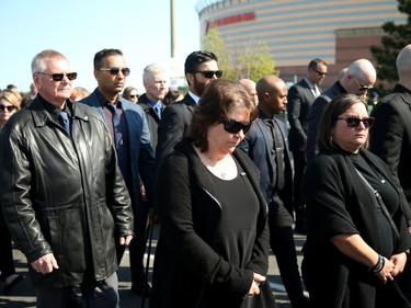 Thousands of officers and other mourners march ahead of the hearse carrying Sgt. Eric Mueller to his funeral at the Canadian Tire Centre in Ottawa Thursday morning.