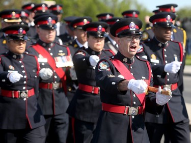 Thousands of officers march ahead of the hearse carrying Sgt. Eric Mueller to his funeral at the Canadian Tire Centre in Ottawa Thursday morning.