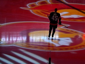 A hockey player on the ice with the Senators logo visible