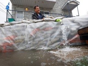 Larry Paul keeps an eye on his sub pump on Rue Blais in Gatineau Wednesday. Larry is 72 years old and he remembers swimming on his street when he was nine years old during a flood.