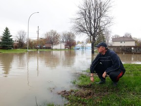 Dozens of streets were closed near Rue Saint-Louis in Gatineau due to flooding Wednesday. Stephane Blais examines the water level on Rue Saint-Louios in Gatineau. Stephane works on the street and had spent the past 12 hours sandbagging his place of employment.
