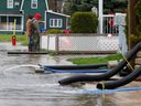 Des dizaines de rues ont été fermées près de la rue Saint-Louis à Gatineau en raison des inondations de mercredi.  Deux hommes vérifient les niveaux d'eau sur la rue Jacques-Cartier mercredi.  