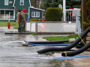 Dozens of streets were closed near Rue Saint-Louis in Gatineau due to flooding Wednesday. Two men check on the water levels on Rue Jacques-Cartier Wednesday.