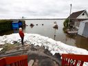 OTTAWA - 4 mai 2023 - Dan Larrivee regarde la montée des eaux de la rivière des Outaouais derrière sa maison Leo Lane à Cumberland jeudi.   