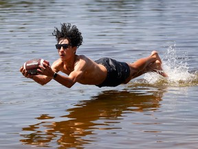 Rayen Ben Tamarzizt cools off playing some water football at Mooney's Bay Beach in Ottawa Wednesday.