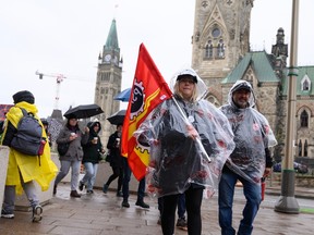 Members of the Public Service Alliance of Canada (PSAC) walk in the rain on a picket line outside the Office of the Prime Minister on Monday April 24. The strike was called off early Monday morning.