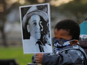 Four-year-old Senty Banutu-Gomez holds a photograph of Emmett Till, the 14-year-old Black who was lynched in 1955.