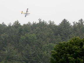 A float plane circles the forest fire nearby