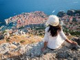 Traveller looking at view of Dubrovnik Old Town, in Dalmatia, Croatia, the prominent travel destination of Croatia. Dubrovnik old town was listed as UNESCO World Heritage Sites in 1979.