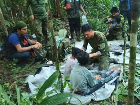 Members of the army assist four Indigenous children who were found alive