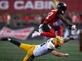 Ottawa Redblacks kick returner and defensive back Brandin Dandridge (37) leaps over the tackle of Edmonton Elks punter Jake Julien (9)