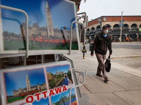 OTTAWA - June 6, 2023 - A man walks with his mask on in the ByWard Market in Ottawa Tuesday. TONY CALDWELL, Postmedia.