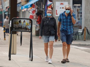 Debbie Wallace and Paul Gecius walk in the Byward Market in Ottawa with their masks on due to the poor air quality Tuesday.