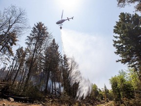 A helicopter drops water on a hot spot at a wildfire in Tantallon, N.S. in this Thursday, June 1, 2023 handout photo.