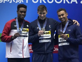Medalists, from left to right, Josh Liendo of Canada, silver, Maxime Grousset of France, gold, and Dare Rose of the U.S., bronze celebrate during the medal ceremony for the men's 100m butterfly at the World Swimming Championships in Fukuoka, Japan, Saturday, July 29, 2023.