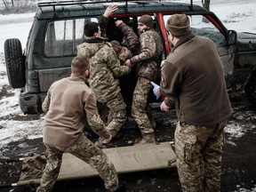 Paramedics receive an injured Ukrainian serviceman who stepped on an anti-personnel land mine at a stabilisation point for emergency treatment, near the frontline in the Donetsk region on January 29, 2023, amid the Russian invasion of Ukraine.