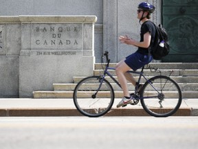 A cyclist makes his way past the Bank of Canada in Ottawa.