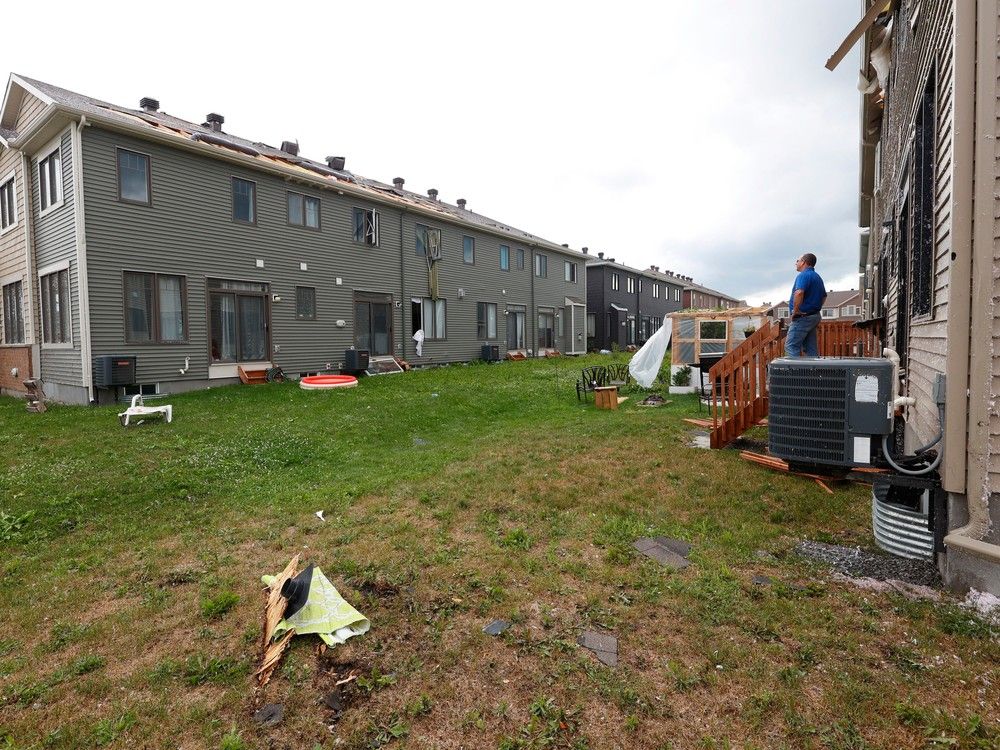 Families go outside their home to check out the damage to their homes and neighbourhood after a tornado rips through Barrhaven