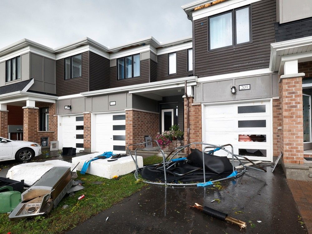 Families go outside their home to check out the damage to their homes and neighbourhood after a tornado rips through Barrhaven