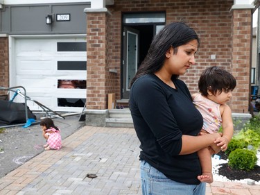 Families go outside their home to check out the damage to their homes and neighbourhood after a tornado rips through Barrhaven