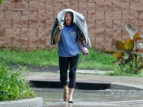A woman walks through a rain storm