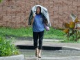 A woman walks through a rain storm