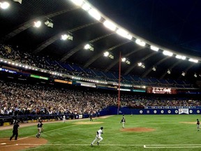 As the pop-up fly ball (seen just above the left-hand side of the lights) reaches its apex inside the Olympic Stadium, Montreal Expo Terrmel Sledge runs toward first base. The caught ball by Florida Marlins third baseman Mike Mordecai put an end to the Expos and Major League Baseball in Montreal on Sept. 29, 2004.
