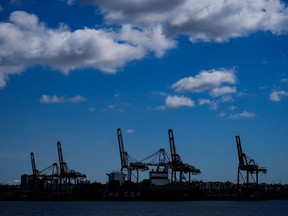Gantry cranes used to load and unload cargo containers from ships at port are silhouetted while seen from the harbour, in Vancouver, on Tuesday, April 25, 2023.
