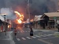 People watch as smoke and flames fill the air from raging wildfires on Front Street in downtown Lahaina, Maui on Tuesday, Aug. 9, 2023.