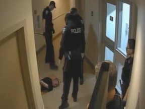 Ottawa police Const. Goran Beric (centre) is seen holding his baton after a violent takedown inside an Ottawa Community Housing complex on Aug. 4, 2021.