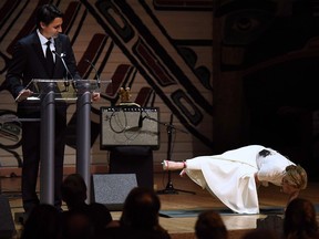 Prime Minister Justin Trudeau looks on as his wife Sophie Grégoire Trudeau performs a yoga pose