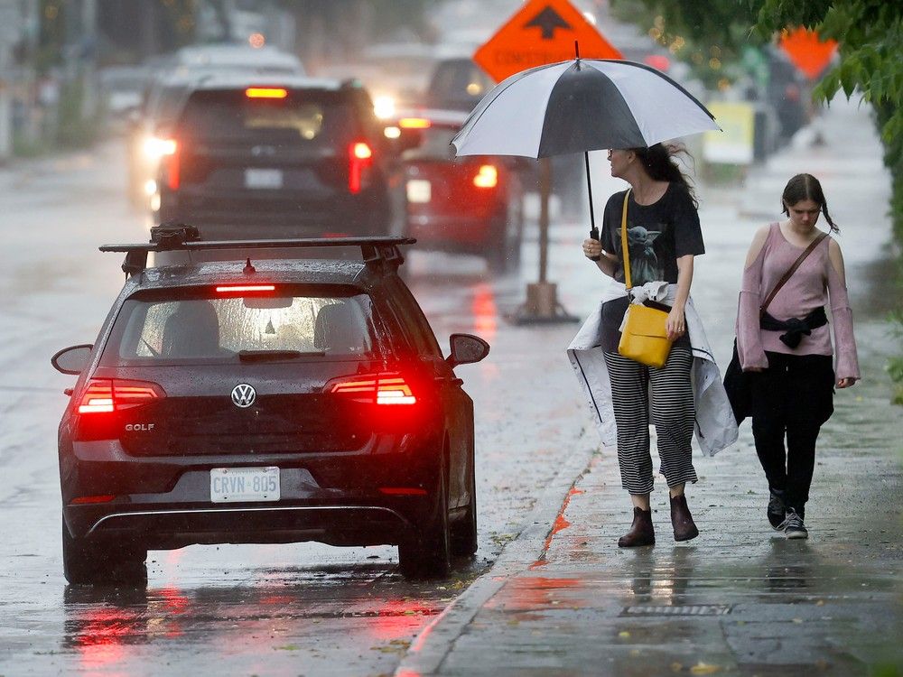 OTTAWA - July 13, 2023 - Walking through a rain storm in Ottawa.