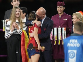 President of Spain's soccer federation, Luis Rubiales, right, hugs Spain's Aitana Bonmati on the podium